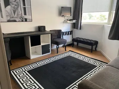 a living room with a desk and chairs and a rug at Très Bel Appartement Palais Festivals Plage Croisette Suquet in Cannes