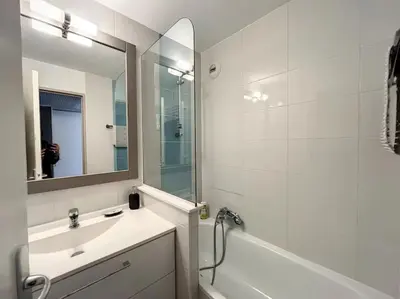 a bathroom with a sink and a tub and a mirror at Très Bel Appartement Palais Festivals Plage Croisette Suquet in Cannes