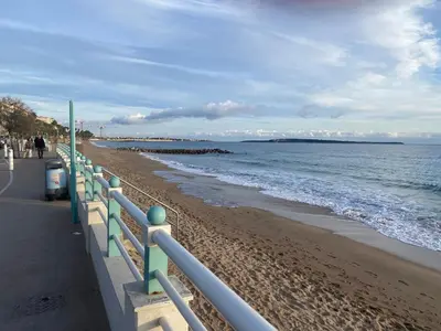 a beach with a fence next to the ocean at Très Bel Appartement Palais Festivals Plage Croisette Suquet in Cannes