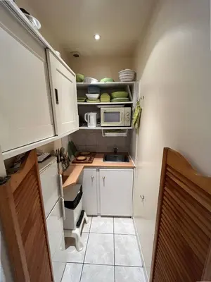 a small kitchen with white cabinets and a microwave at Cannes Croisette - PALAIS MIRAMAR - Studio au calme avec terrasse in Cannes