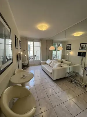 a living room with a couch and a table at Cannes Croisette - PALAIS MIRAMAR - Studio au calme avec terrasse in Cannes