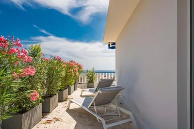 a row of chairs sitting on a balcony with flowers at Suite Horizon Penthouse d'exception avec Vue Mer à Cannes in Cannes