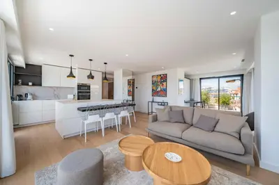 a living room and kitchen with a couch and a table at Suite Horizon Penthouse d'exception avec Vue Mer à Cannes in Cannes