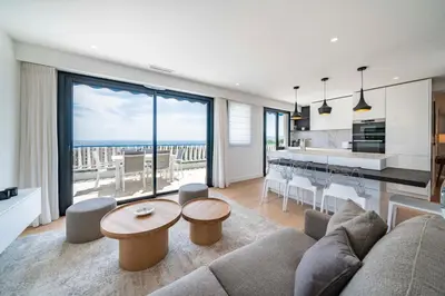 a living room with a couch and a table at Suite Horizon Penthouse d'exception avec Vue Mer à Cannes in Cannes