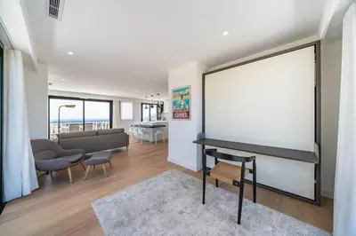 a living room with a large blank screen on the wall at Suite Horizon Penthouse d'exception avec Vue Mer à Cannes in Cannes