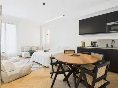 a kitchen and living room with a table and a bed at Appartement centre cannes croisette / palais festival in Cannes