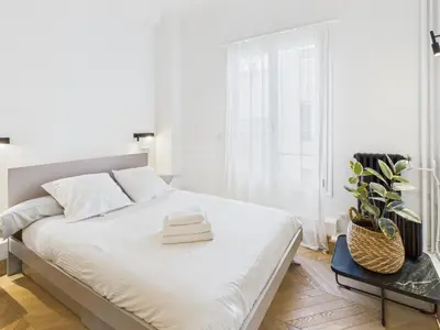 a white bedroom with a bed with a plant on it at Appartement centre cannes croisette / palais festival in Cannes