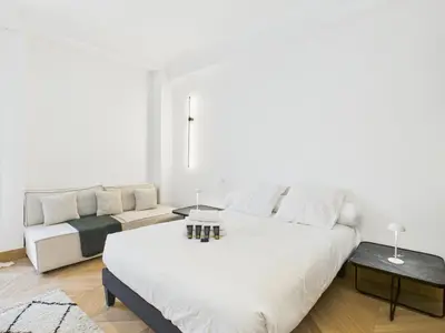 a white bedroom with a large bed and a couch at Appartement centre cannes croisette / palais festival in Cannes