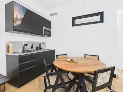 a kitchen with a wooden table and chairs in a room at Appartement centre cannes croisette / palais festival in Cannes