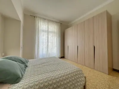 a bedroom with a bed and a large window at Appartement central rue Hoche in Cannes