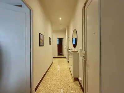 a hallway of a bathroom with a sink and a mirror at Appartement central rue Hoche in Cannes