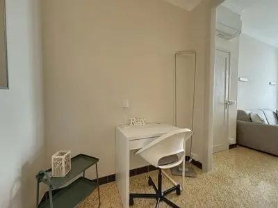 a bathroom with a white desk and a chair in a room at Appartement central rue Hoche in Cannes