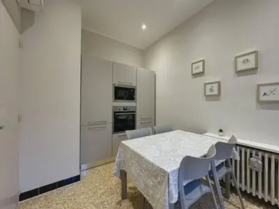 a white dining room with a table and chairs at Appartement central rue Hoche in Cannes