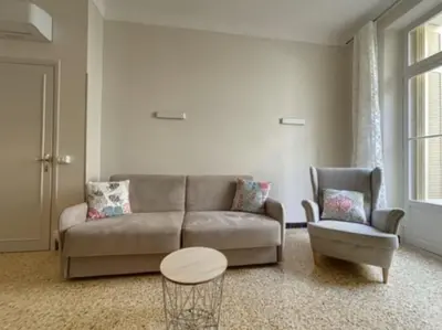 a living room with a couch and a table and a chair at Appartement central rue Hoche in Cannes