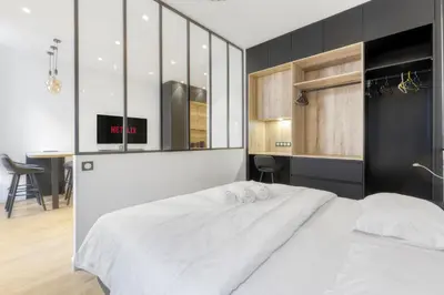 a bedroom with a white bed and a table at 1 Chambre Modern L- Calme - Hypercentre à 2 minutes du Palais in Cannes