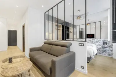 a living room with a couch and a bed at 1 Chambre Modern L- Calme - Hypercentre à 2 minutes du Palais in Cannes