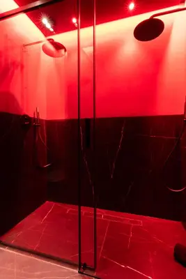 a bathroom with a shower with red lights in it at Évasion intime : Love Room de luxe à Cannes in Cannes