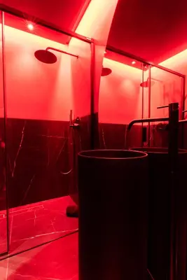 a bathroom with red lighting and a shower and a sink at Évasion intime : Love Room de luxe à Cannes in Cannes