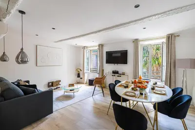 a living room with a table and a couch at 15 RIOUFFE - Splendide appartement 6 couchages à 50m à pieds du Palais in Cannes