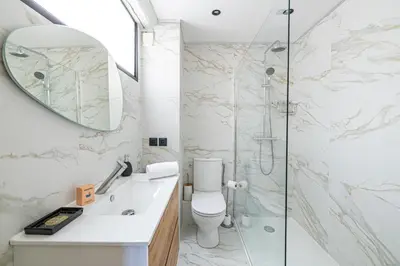 a bathroom with a toilet and a glass shower at 15 RIOUFFE - Splendide appartement 6 couchages à 50m à pieds du Palais in Cannes
