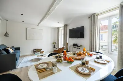 a living room with a table with food on it at 15 RIOUFFE - Splendide appartement 6 couchages à 50m à pieds du Palais in Cannes