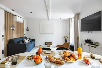 a table with plates of food on it in a living room at 15 RIOUFFE - Splendide appartement 6 couchages à 50m à pieds du Palais in Cannes