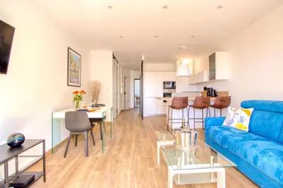 a living room with a blue couch and a table at Cannes Croisette - 4 Personnes - Vue mer in Cannes