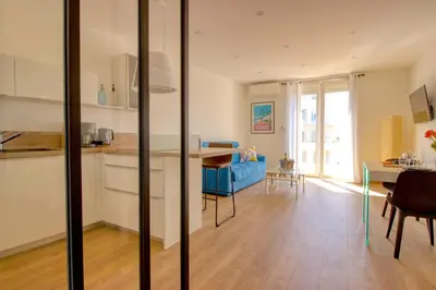 a kitchen and living room with a blue couch at Cannes Croisette - 4 Personnes - Vue mer in Cannes