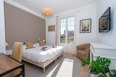 a bedroom with a bed and a couch and a television at Cannes 3 BR 3 bath close to Palais & Croisette by Olam Properties in Cannes