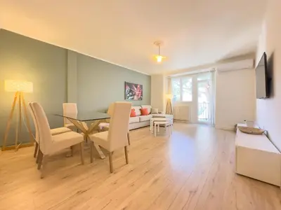 a living room with a table and chairs and a couch at Le Palm by Winsome Destination in Cannes
