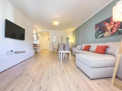 a living room with a white couch and a tv at Le Palm by Winsome Destination in Cannes
