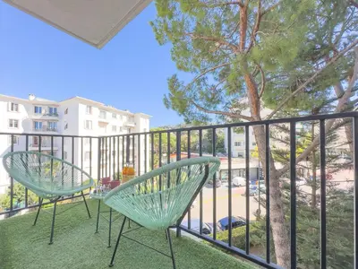 a balcony with two chairs and a tree at Le Palm by Winsome Destination in Cannes