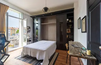 a bedroom with a bed and a table and a window at Magnifique 2 chambres Centre Cannes - 4 personnes - WIFI Terrasse in Cannes
