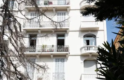 a white building with balconies and trees at Magnifique 2 chambres Centre Cannes - 4 personnes - WIFI Terrasse in Cannes