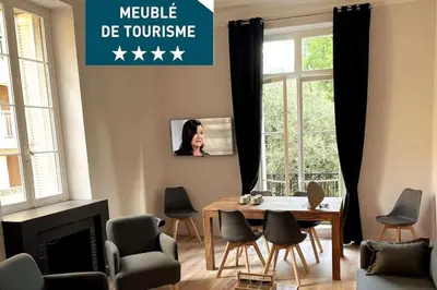 a living room with a table and chairs and a tv at Augusta Palace - T3 **** 74m² - 150m Croisette in Cannes