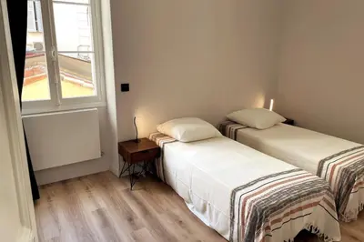 two beds in a room with a window at Augusta Palace - T3 **** 74m² - 150m Croisette in Cannes