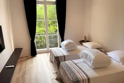 two beds in a room with a window at Augusta Palace - T3 **** 74m² - 150m Croisette in Cannes