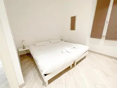 a white bed in a white room with a mirror at Tony Allard By Winsome Destination 2E in Cannes