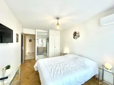 a white bedroom with a bed and a tv at Vezelay 3 luxury 3 bedrooms, by Welcome to Cannes in Cannes