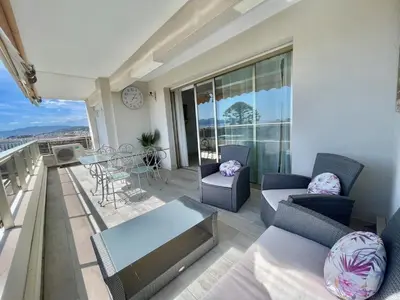 a living room with a balcony with a table and chairs at Vezelay 3 luxury 3 bedrooms, by Welcome to Cannes in Cannes