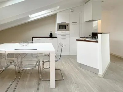 a kitchen with white cabinets and a table and chairs at Tony Allard By Winsome Destination 4A in Cannes