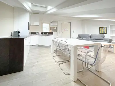 a kitchen and living room with a white table and chairs at Tony Allard By Winsome Destination 4A in Cannes