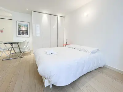 a white bedroom with a large bed and a desk at Tony Allard By Winsome Destination 3F in Cannes