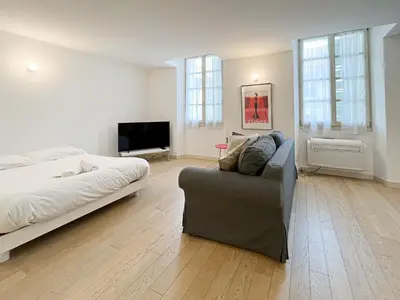 a bedroom with a bed and a couch and a television at Tony Allard By Winsome Destination 3F in Cannes