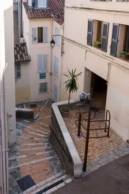an alley with a building and a potted plant at Le Suquet - Charming apartment in Cannes