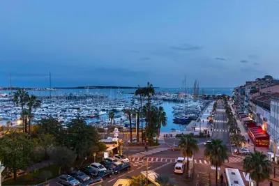 a busy city street with cars parked in a harbor at Le Suquet - Charming apartment in Cannes