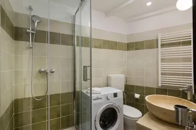 a bathroom with a shower and a washing machine at Le Suquet - Charming apartment in Cannes