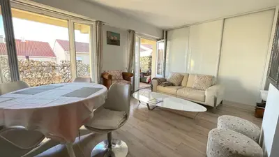 a living room with a table and chairs and a couch at Comfortable and modern two bedroom in Cannes