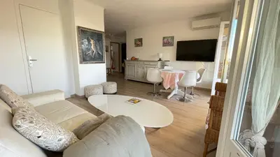 a living room with a couch and a table at Comfortable and modern two bedroom in Cannes