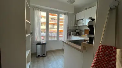 a kitchen with white cabinets and a window at Comfortable and modern two bedroom in Cannes